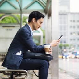 Man with hearing aids waits for public transport