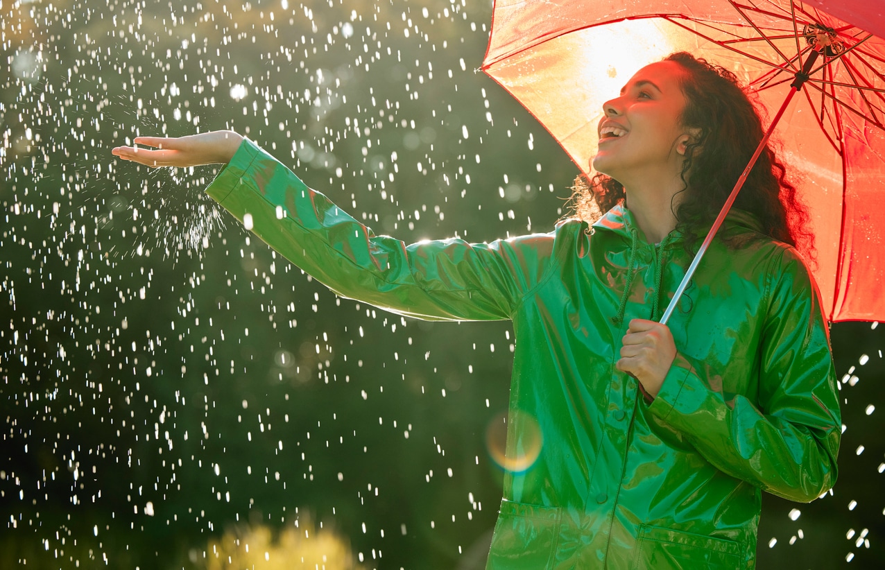 Young woman under an umbrella in the rain.