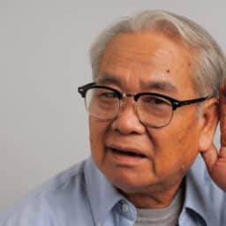 Man cups hand behind ear to hear